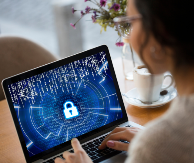 Une femme regarde son ordinateur et applique les conseils pour lutter contre la cybercriminalité.